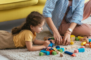 Pictured: child playing blocks with an adult